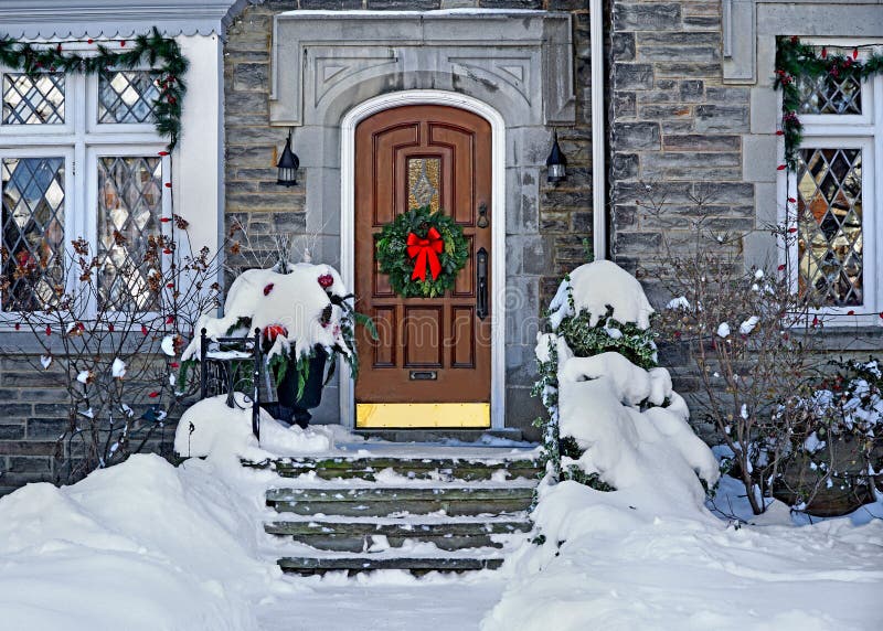 Front door with Christmas wreath. On a snowy day royalty free stock photography